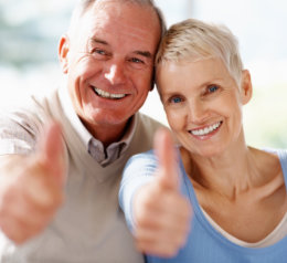 senior couple showing thumbs up