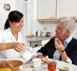 caretaker preparing meal for her patient